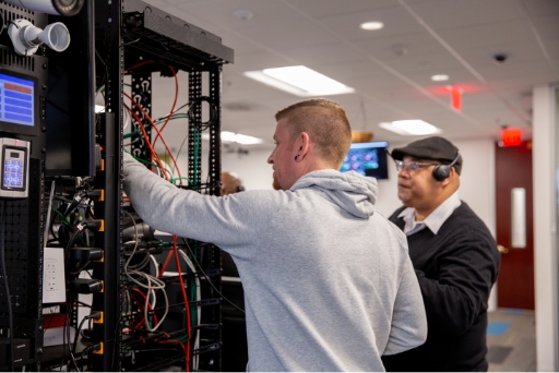 Tech support agents on phone in front of one of SnapAv's av rack trouble shooting an error